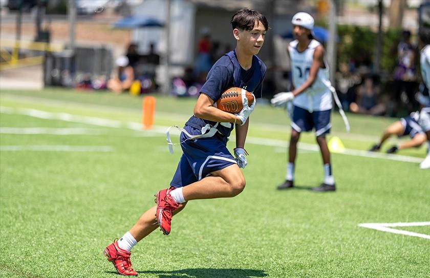 Boy Select Team athlete a running the ball during a drill at Select Bowl practice.